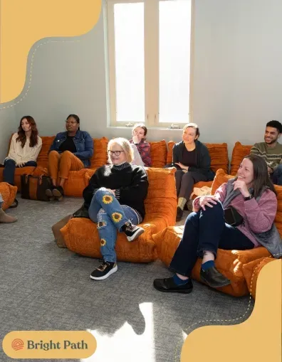 Group seated on orange lounge chairs in a Bright Path group therapy room