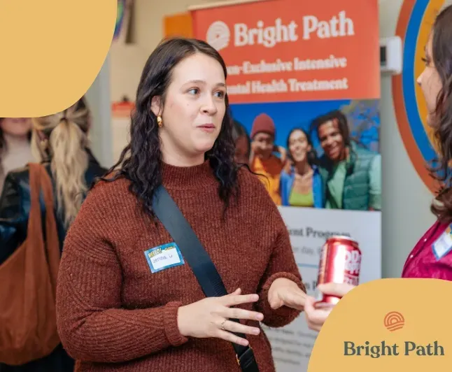 Guest talking in front of a Bright Path teen mental health treatment banner at an open house