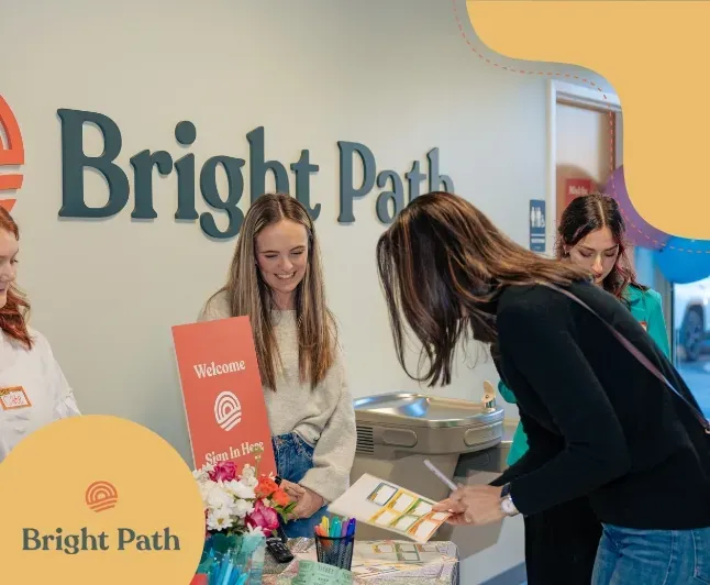 Visitors at the Bright Path welcome table in the front lobby