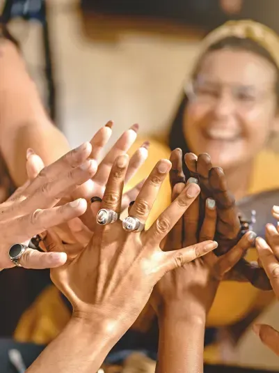 Group of raised hands meeting in a high five