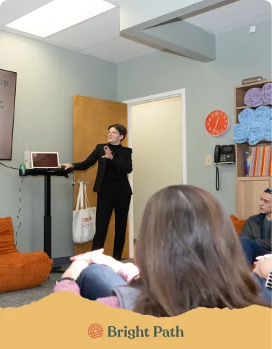 Speaker presenting to a seated group in a Bright Path group room