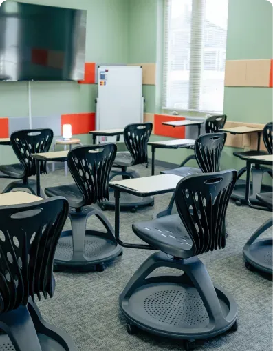 Classroom with black rolling chairs, desks and a whiteboard at Bright Path