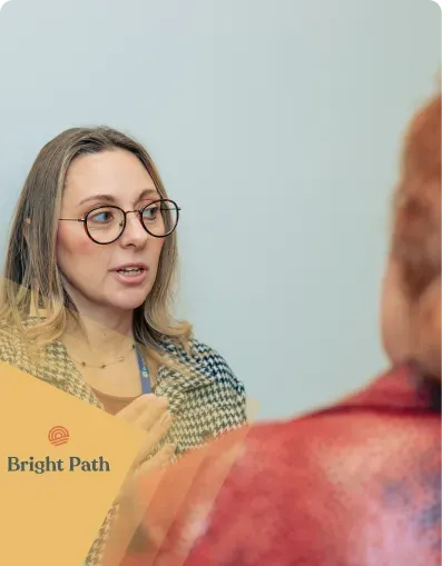 Woman with glasses talking with a guest at a Bright Path event