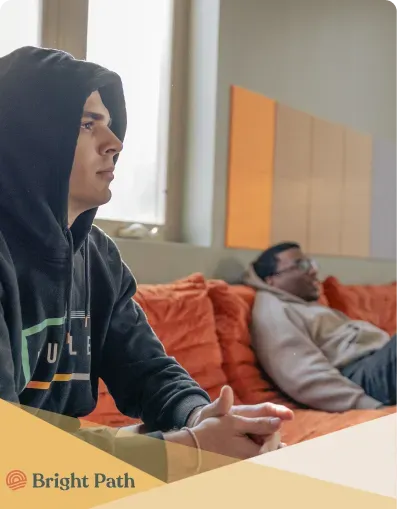 Two teens relaxing on orange lounge seating at Bright Path