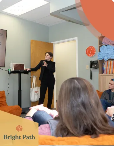 Speaker presenting to a seated group in a Bright Path group room