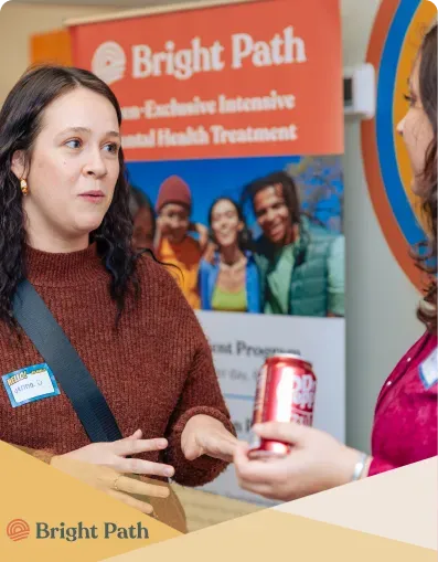 Guest smiling in front of a Bright Path banner at an open house