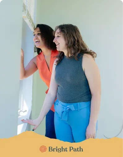 Two women looking at a wall display at Bright Path