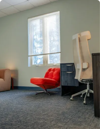 Office with a red swivel chair and a desk beside a window at Bright Path