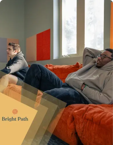 Two young men relaxing on orange lounge seating at Bright Path
