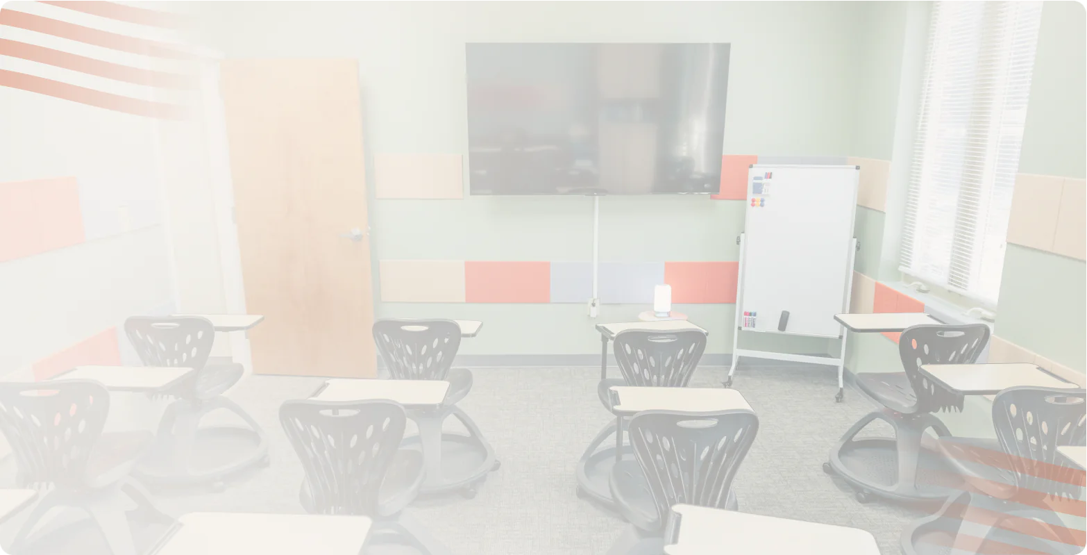 Classroom with student desks, a whiteboard and a wall-mounted TV at the Bright Path facility
