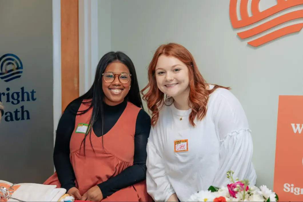 Mekaila Hunter and a colleague smiling beside the Bright Path logo
