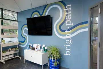 Lobby with a blue Bright Path wall mural and plants at the Wake Forest location