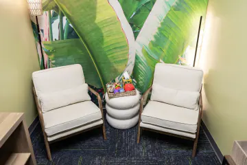 Psychiatric provider office with two cream armchairs and a leaf mural at Bright Path Wake Forest